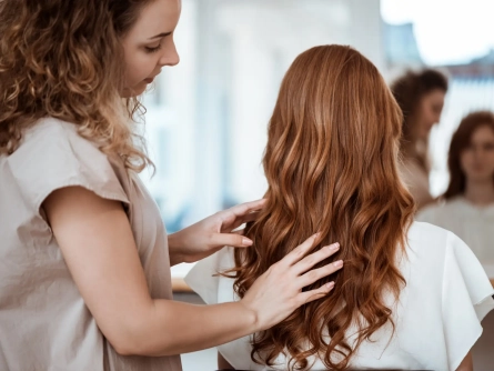 female-hairdresser-making-hairstyle-redhead-woman-beauty-salon_176420-4476