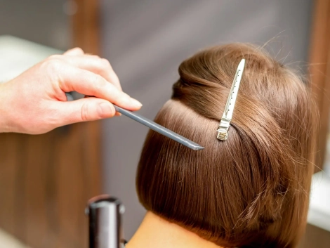 hairstylist-is-straightening-short-hair-young-brunette-woman-with-flat-iron-hairdresser-salon-close-up_141172-10045